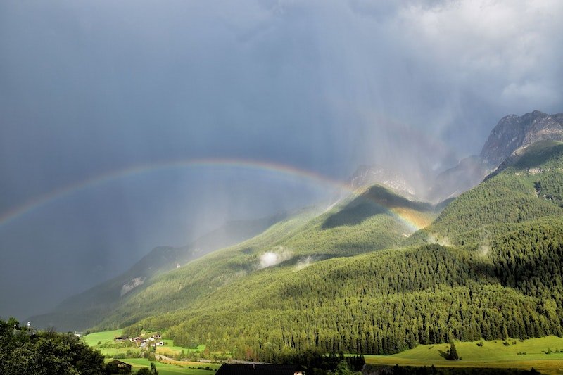 Im Bild ist ein Regenbogen über Scuol zu sehen. 